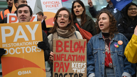 Младши лекари държат плакати, докато стачкуват пред болницата на Университетския колеж в Лондон, 11 април 2023 г. 