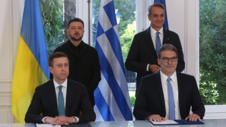 Изпълнителният директор на DEPA, Константинос Ксифарас (вдясно), и изпълнителният директор на Naftogaz Group, Сергей Корецки (вляво), подписват енергийно споразумение в присъствието на Мицотакис и Зеленски.