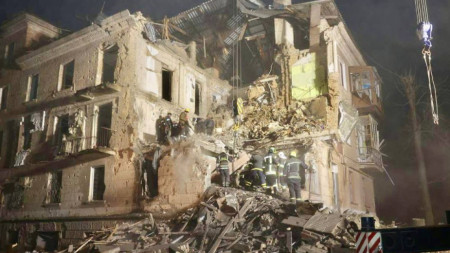 Спасители се опитват да достигнат момче, затрупано под развалините на жилищна сграда в Кривой рог след попадение на руска ракета, 16 декември 2022 г.