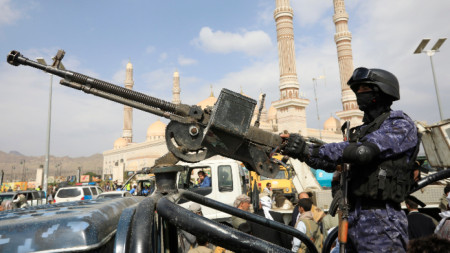 Войник на хутите насочва картечница към автомобил, докато патрулира по време на протест срещу САЩ и Израел в Сана, Йемен.