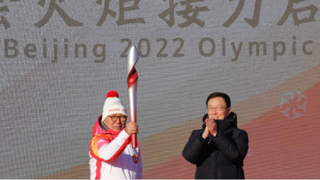 Вицепремиерът Хан Чжън аплодира факлоносеца Луо Джиуан, който е бивш световен шампион по бързо пързаляне с кънки.