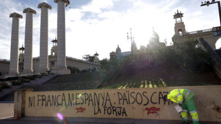 Работник чисти графити срещу срещата на върха Франция-Испания, направени от каталунски сепаратисти, пред Националната художествена галерия на Каталуния в Барселона