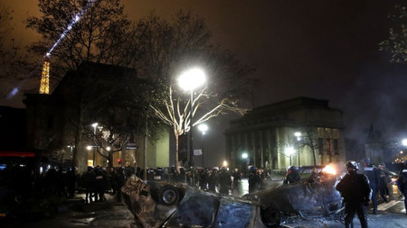 Изгорели коли на фона на Триумфалната арка в Париж при сблъсъци на полицията и и протестиращи в събота вечер.