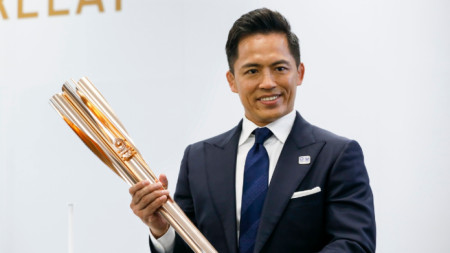 Трикратният олимпийски шампион в джудото Тадахиро Номура показва факела.
