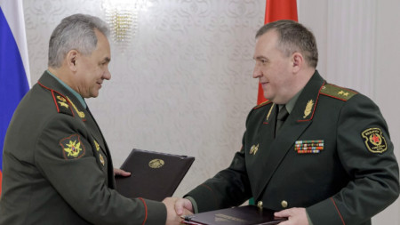 Министрите Сергей Шойгу (вляво) и Виктор Хренин обменят подписаните документи по процедурата за съхраняване на руски нестратегически ядрени оръжия в специално хранилище, Минск, Беларус, 25 май 2023 г. 