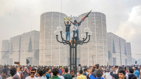 Протестиращи празнуват пред парламента на Бангладеш след новината за оставката на премиера Шейх Хасина, в Дака, Бангладеш, 5 август 2024 г.