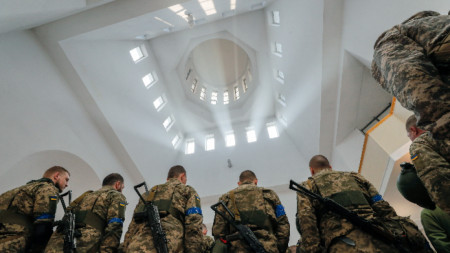 Бойци от украинската териториална отбрана присъстват на религиозна служба в Киев. 