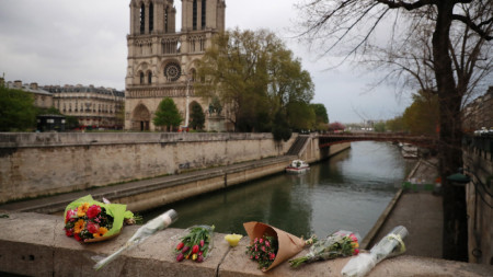 Оставени от туристи цветя в района на опожарената катедрала в Париж. 
