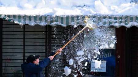 Служител чисти сняг в Букурещ.
