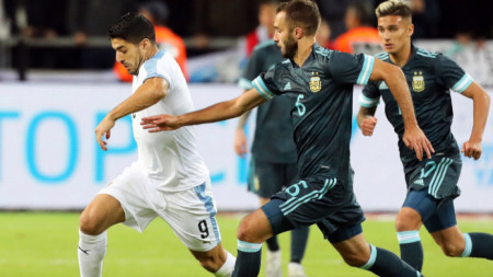 Луис Суарес (в бяло) надбягва защитата на Аржентина.