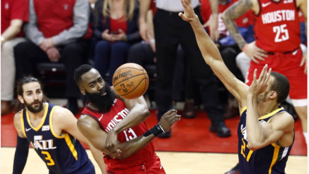 Хардън подава топката между двама баскетболисти на Юта.