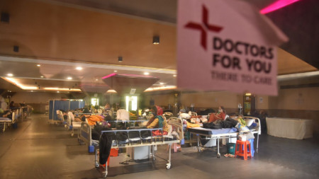 Пациенти с коронавирус лежат в център за грижи и изолация в помещение край болница в Делхи.