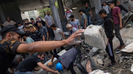 Палестинци търсят оцелели в сграда, разрушена по време на израелски бомбардировки в бежанския лагер Рафах в Ивицата Газа във вторник, 17 октомври 2023 г.
