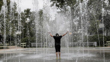 Момче се охлажда във фонтан в Атина, 12 юни 2024 г.