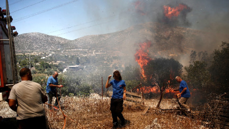 Местните пожарникари се борят с пожара в района на Кувара в Атика, Гърция, 17 юли 2023 г.