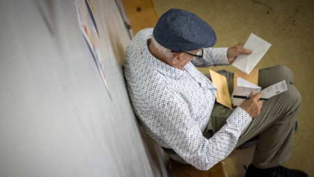 Възрастен мъж избира бюлетините си преди да гласува в избирателна секция в Памплона, Испания, 23 юли 2023 г.