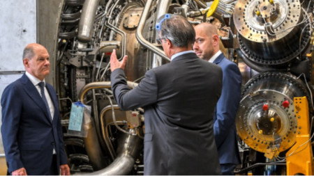 Олаф Шол (вляво) разглежда газовата турбина на Simens след пристигането ѝ от ремонта в Канада