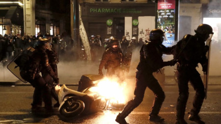 Полицаи махат подпален скутер, след като в събота вечерта в Париж се стигна до сблъсъци между силите на реда и част от демонстриращите „жълтите жилетки“  в т.нар. „жълта нощ“.