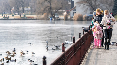 Хората хранят птиците в парка Валеа Морилор в Кишинев, януари 2021 г.