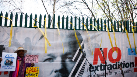 Протестиращ с плакати, призоваващи за освобождаването на Джулиан Асандж, Лондон, 23 март 2022 г.