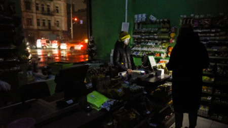Продевачи светят с фенерчета в магазин в Киев, където продължава да има режим на тока