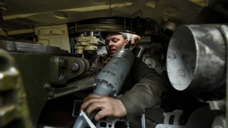 Украински военен зарежда снаряд в танк край Бахмут, 10 април 2023 г.