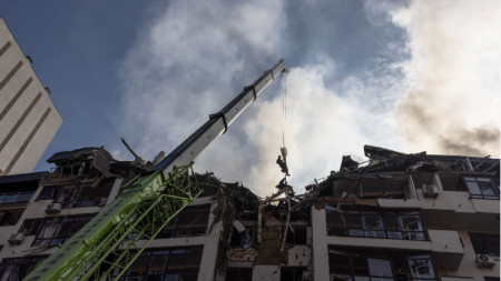 Спасители работят по повредената жилищна сграда в Шевченковския квартал в Киев, 26 юни 2022 г. Сутринта множество въздушни удари удариха центъра на Киев.