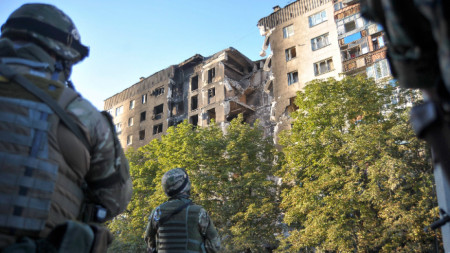 Украински войници оглеждат бомбардирани стради в Лисичанск