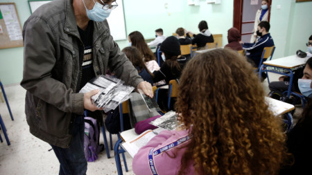 Учител раздава маски на ученици в гимназия в Атина, 1 февруари 2021 г.