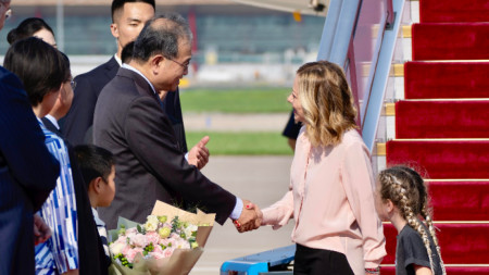 Италианският министър-председател Джорджа Мелони (вдясно), заедно с дъщеря си Джиневра, на летището в Пекин, където е посрещната от местни служители, 27 юли 2024 г.