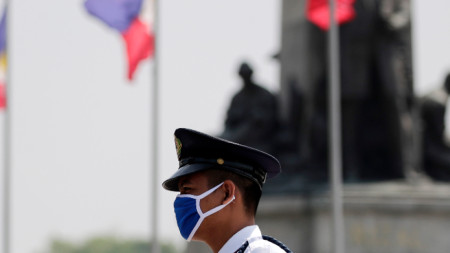 Офицер от силите за сигурност на Филипините е на поста си със защитна маска, Манила, 14 март 2020 г.