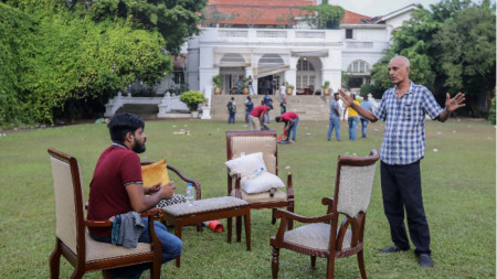 Участници в протестите в Шри Ланка разговарят в градината на резиденцията на премиера в столицата Коломбо, 10 юли 2022 г., ден след като официални резиденции бяха щурмувани. Протестите  заради най-тежката икономическа криза от десетилетия разтърсват страната от месеци.