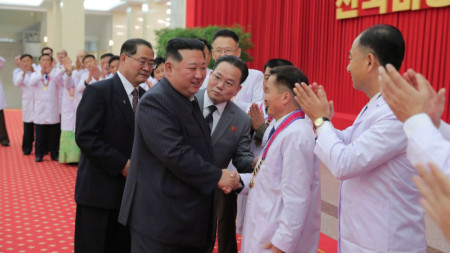 Лидерът на КНДР Ким Чен-ун се ръкува със здравни ръководители, след като обяви победа над коронавируса, 10 август 2022 г.