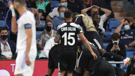 Играчите на Шериф ликуват след победата над Реал (Мадрид), докато Карим Бензема (вляво) не може да повярва на случилото се