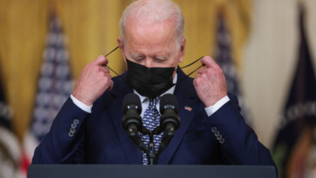 Президентът на САЩ Джо Байдън маха маската си, преди да коментира приетия от Сената план за инвестиции в инфраструктура.