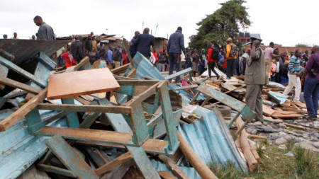 Полицай и местни жители край рухналата класна стая на училище в Найроби.
