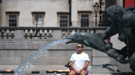 Мъж се разхлажда до фонтан на площад Трафалгар в Лондон, 18 юли 2022 г. 