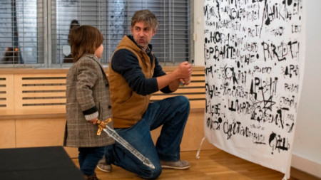 Един от участниците - Стефан Чинов, със сина си пред своята работа „1000 думи”, в която са вплетени онлайн отправени заплахи, отпечатани върху платове