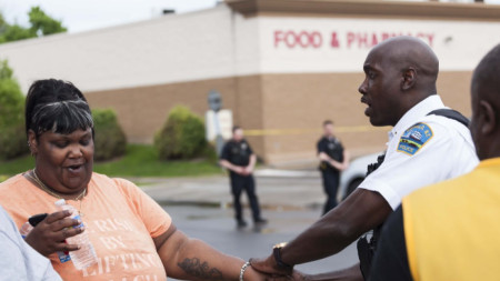 Полицай успокоява жена край магазина в Бъфало, щата Ню Йорк, където бе извършена атаката