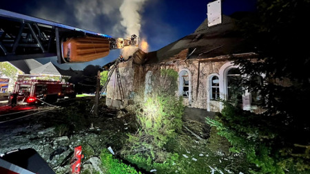 Украински спасители опитват да потушат пожар, след като руски дрон е ударил частна сграда в село в Киевска област.