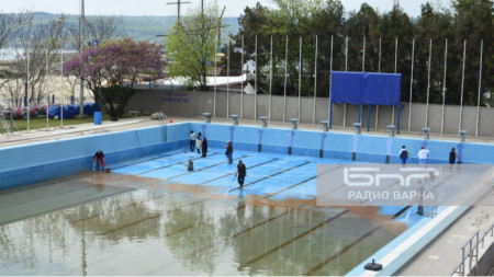 Работници почистват басейн 