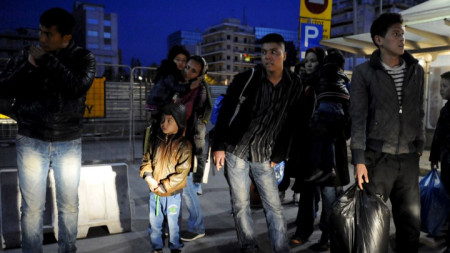 Мигранти чакат на автобусна спирка в Солун.