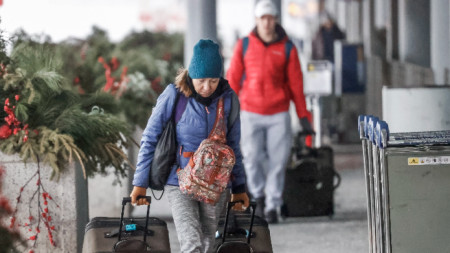 Пътници пристигат, за да се регистрират за полетите си, преди да нахлуе зимната буря, която заплашва да затвори въздушния трафик на международното летище О'Хеър в Чикаго, Илинойс, САЩ, 22 декември 2022 г. 