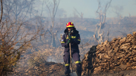 Пожарникар се бори с огнената стихия в Гърция.