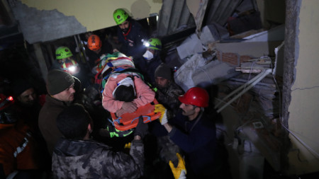 Спасителен екип евакуира жена, оцеляла след 90 часа под развалините на жилищен блок в град Хатай, Югоизточна Турция, 9 февруари 2023 г.