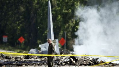 Опашката на самолета С-130 стои на път в Порт Уентуърт край Савана в щата Джорджия, докато спасителни екипи работят на мястото на катастрофата.