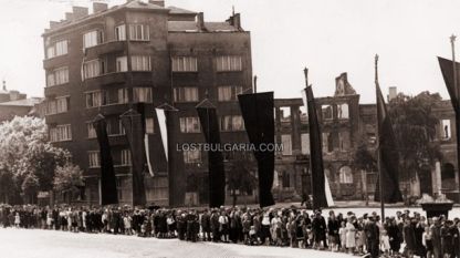 Опашка за поклонение пред тялото на Георги Димитров на фона на бомбардирани сгради на площад “Народно събрание”, София, юли 1949 г.
