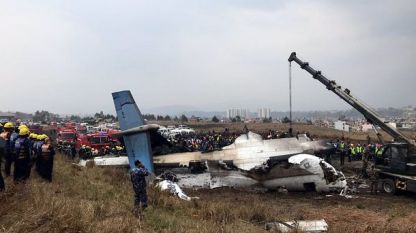 Спасителни екипи до останките от разбилия се пътнически самолет край международното летище на Катманду.