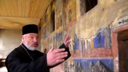 Отец Александър Стоев показва и разказва за външните стенописи на храма