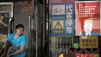 Жена напуска ресторант в китайския град Гуанчжоу, на който има плакат със съобщение, че цените за американци са 25% по-високи заради започнатата от президента Доналд Тръмп търговска война.